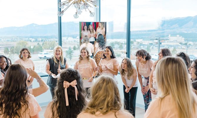 The Something New staff gathers with Mindi (in black vest) during their annual sample sale.